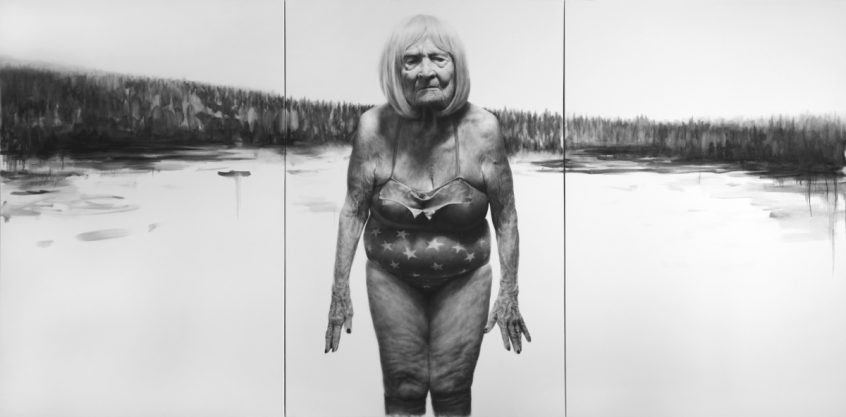 Older woman standing by a lake
