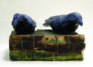 two ceramic birds on a resin book
